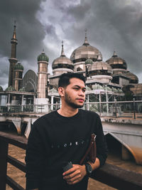 Portrait of young man standing against sky