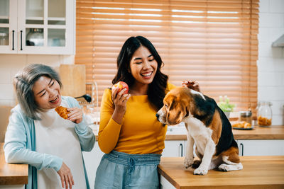 Portrait of young woman with dog at home