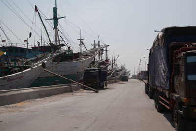 Sailboats moored at harbor against clear sky