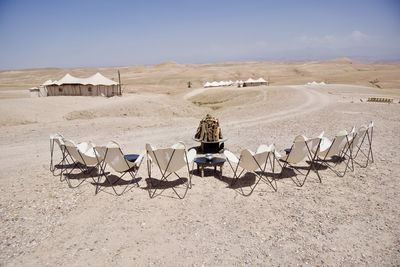 Rear view of people sitting on chair at beach