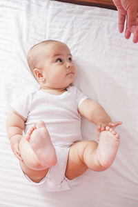 High angle view of cute baby on bed at home