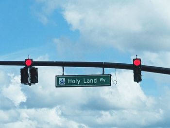 Low angle view of road sign against sky