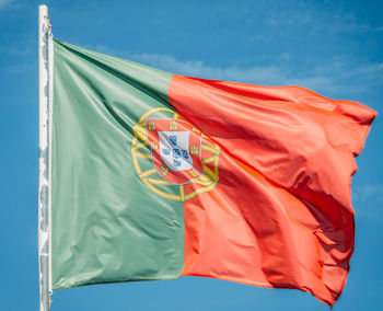 Low angle view of flag against blue sky