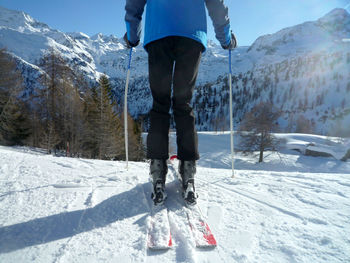 Low section of person skiing on snow covered mountain