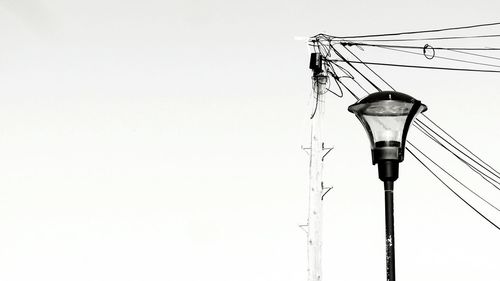 Low angle view of electricity pylon against clear sky