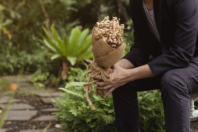 Young man is holding flowers waiting for his lover. for surprise proposal.