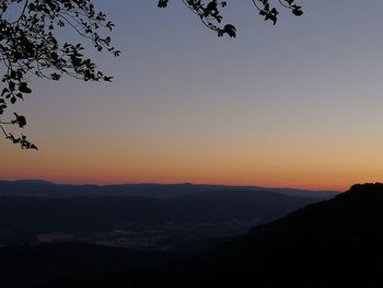 Scenic view of silhouette mountains against orange sky