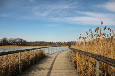 Pier over lake against sky