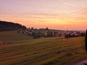 Scenic view of field against sky during sunset