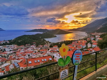 Aerial view of townscape by sea against sky at sunset