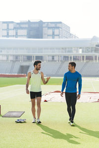 Male athletes walking at sports field