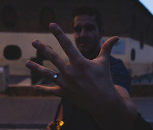 Man showing wedding ring while standing outdoors