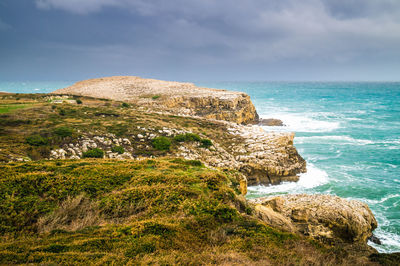 Scenic view of rocks on beach against sky