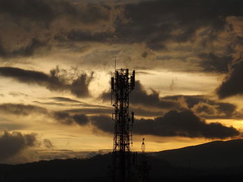 Silhouette communications tower against sky during sunset