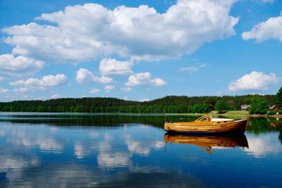 Boat moored in lake against sky