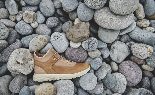 A pair of brown leather waterproof trekking boots on a sea coast. hiking concept.