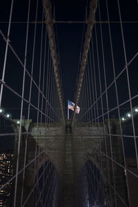 Low angle view of illuminated bridge at night