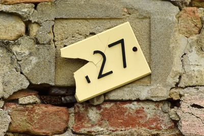 Low angle view of arrow symbol on brick wall