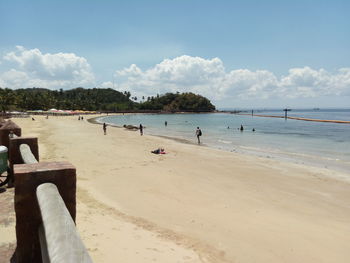 People on beach against sky