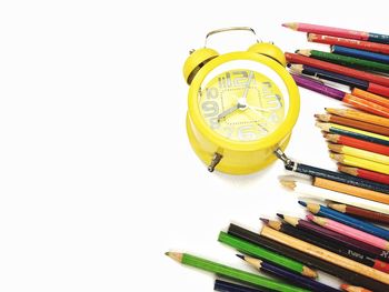 High angle view of colored pencils against white background