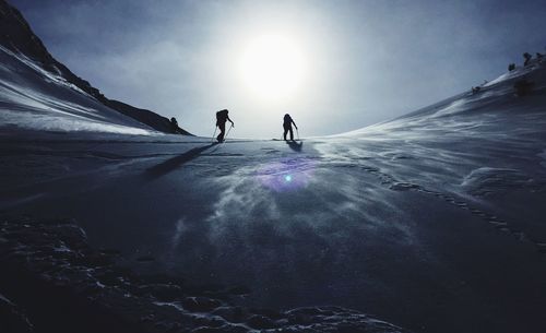 Low angle view of people on snow covered landscape