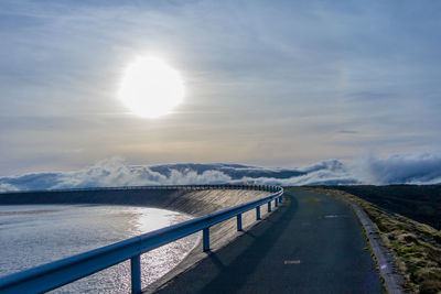 Road by snowcapped mountains against sky during winter