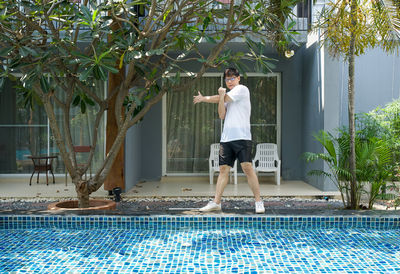 Full length of man standing by swimming pool