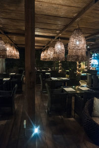 Illuminated lights hanging from glass at restaurant