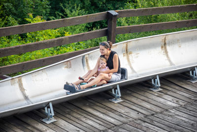 Side view of woman sitting on railing