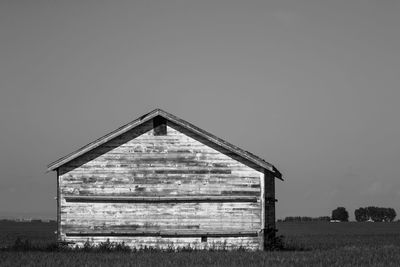 Barn on field against clear sky