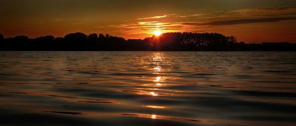 Scenic view of lake at sunset