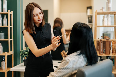 The makeup artist works in her salon, applies professional makeup. beauty industry, make-up