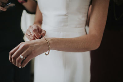 Midsection of bride wearing wedding dress and bracelet