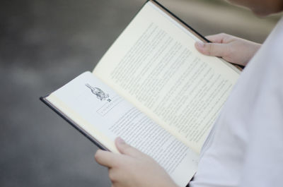 Midsection of person holding book