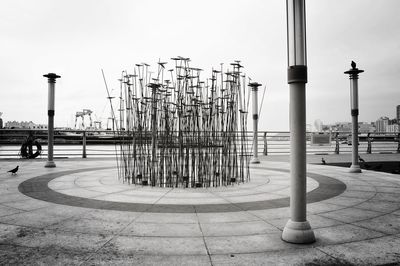 Fishing poles on pier against sky