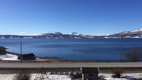 Scenic view of snow covered mountains against clear blue sky