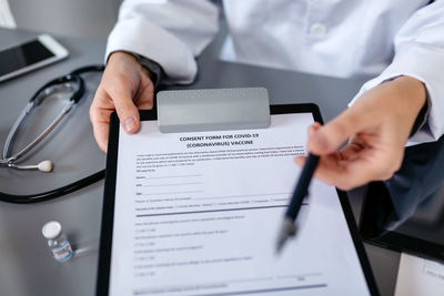 Midsection of person using laptop on table