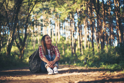 Portrait of smiling young woman sitting on land