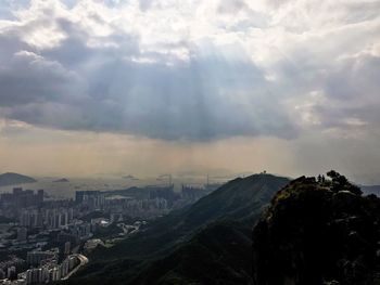 View of cityscape against cloudy sky