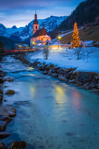 Illuminated buildings against sky during winter