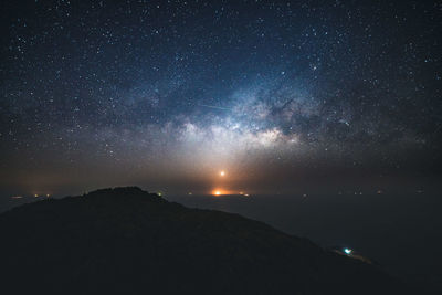 Scenic view of silhouette mountains against star field at night