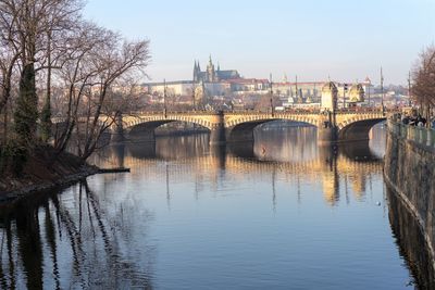 Bridge over river in city against sky