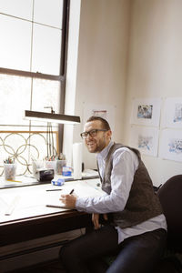 Happy artist looking away while working at art studio