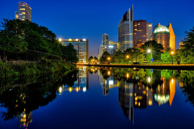 Reflection of buildings in lake at night