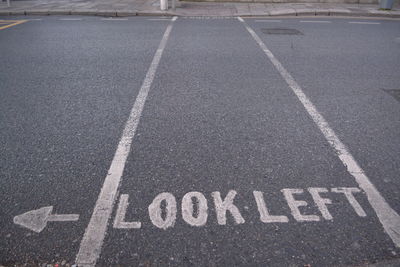 High angle view of arrow symbol and text on road