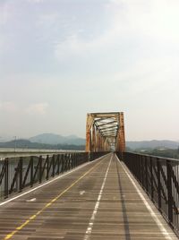 Empty footbridge against sky