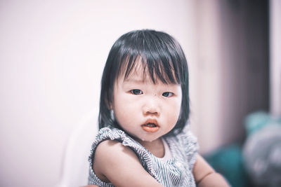 Portrait of cute baby girl drooling at home