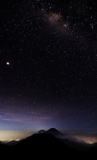 Scenic view of mountains against sky at night