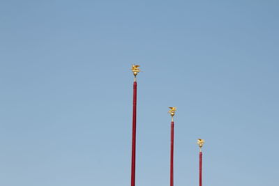 Low angle view of communications tower against clear blue sky, venetian masts, tall poles