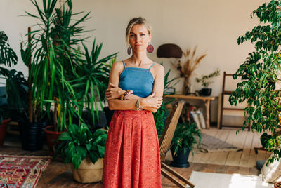 Portrait of gorgeous blonde woman standing in authentic living room interior